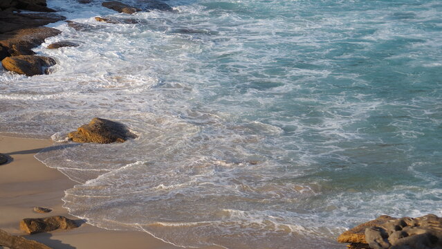 ocean wave on the beach at sunset moment on a summer day