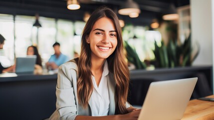 Young and beautiful woman working with laptop in office