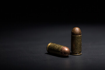 Fototapeta na wymiar Firearm bullets on a black background, 9mm pistol cartridge
