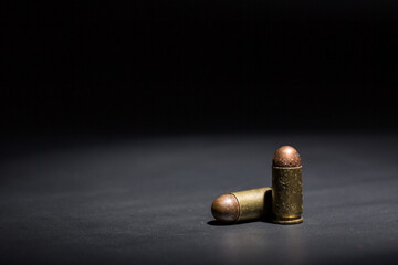 Firearm bullets on a black background, 9mm pistol cartridge - obrazy, fototapety, plakaty