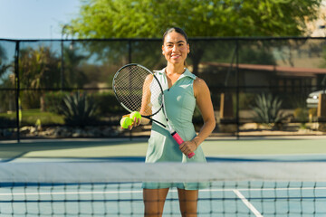 Happy latin woman smiling while playing tennis