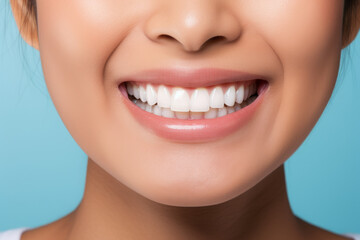 Obraz premium Closeup of beautiful young woman smile with healthy teeth on blue background