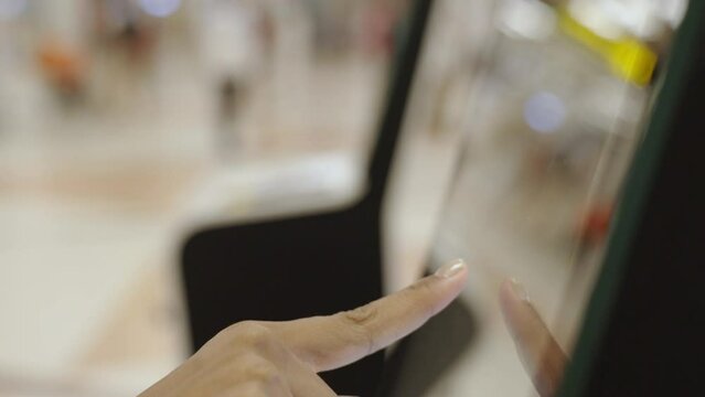 Close-up hand of woman check-in via automatic machines by themselves in the airport to travel or study abroad.