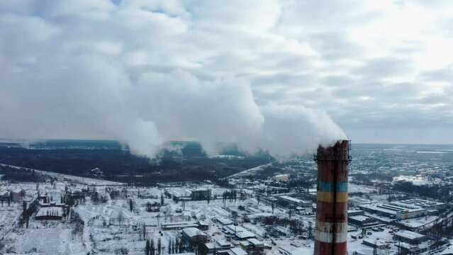 Smog smoke carbon and pollution emissions from industry smokestacks.  Pollution of the atmosphere by an industrial enterprise of the TPS station. Cloudy day in the winter. Cinematic footage