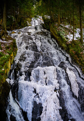 Thundering Brook Falls with frozen ice in snow in Killington, Vermont, USA
