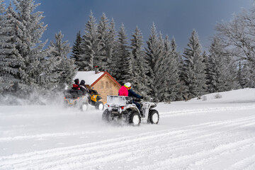 Winter race on an ATV on snow in the forest. Quad bike in motion, ride on top of the mountain on...
