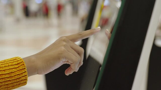 Close-up hand of woman check-in via automatic machines by themselves in the airport to travel or study abroad.