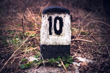The number ten is written on a cement pillar