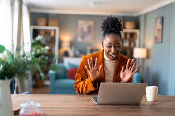 Kind smiling businesswoman, satisfied female entrepreneur waving hand looking at laptop during virtual video conference call in home office. - obrazy, fototapety, plakaty