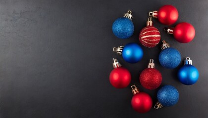 Blue and red Christmas baubles decoration on dark black background with copy space