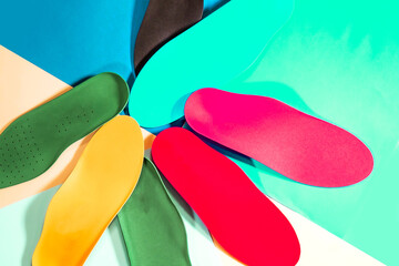 Orthopedic insoles for shoes on a colour background. Foot care