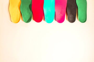 Orthopedic insoles for shoes on a colour background. Foot care