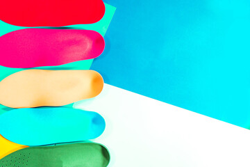 Orthopedic insoles for shoes on a colour background. Foot care