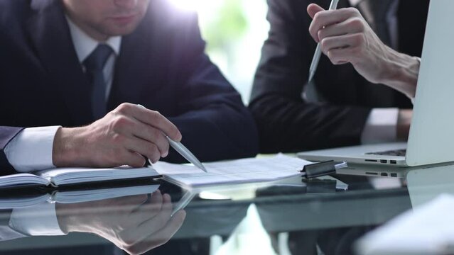 Closeup businessman sign contract or legal document with pen in his hand during corporate meeting for business deal
