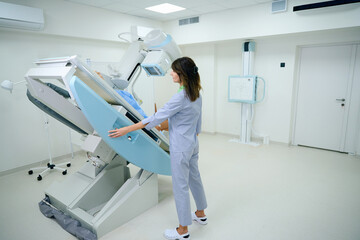 Radiologic technologist preparing adult patient for radiology examination