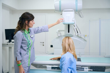 Radiologic technologist preparing adult female for upper extremity radiography