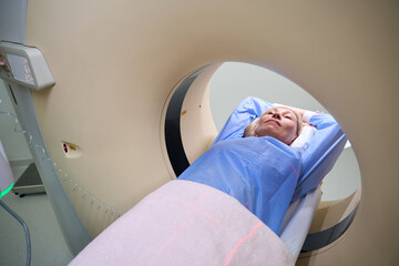 Adult woman is undergoing computed tomography scanning