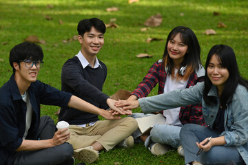 A group of diverse young university students join hands together, Concept of friendship and unity