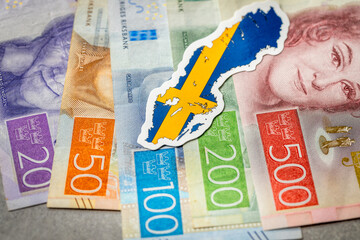 Sweden money, Swedish krona banknotes, national flag and shape of Sweden, Financial concept business, gray background. copy space