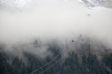 Dramatic image of 3S cable car Eiger express inside cloud