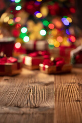 Christmas time. Christmas presents on rustic wooden table. Shallow depth of focus. Colorful bokeh lights.