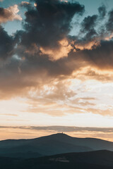 Dramatic sunset with rainy clouds over Lysa Hora peak Beskydy mountains, Czech Republic