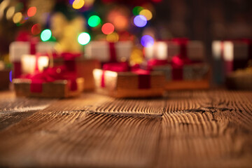 Christmas time. Christmas presents on rustic wooden table. Shallow depth of focus. Colorful bokeh lights.