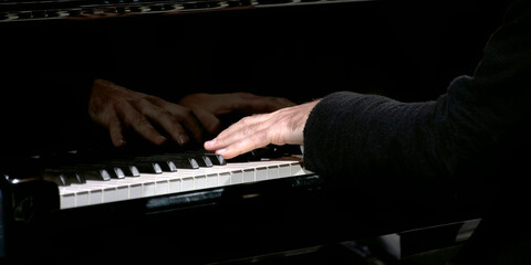pianist hands on piano keyboard during concert