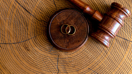 gavel and wedding rings on wooden table