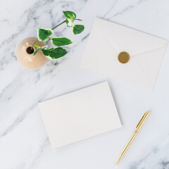 Blank card and envelop with wax seal on marble table