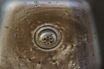 dirty sink in the kitchen, a sink with a swamp after washing vegetables, a sink clogged with earth...