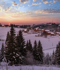 Small and quiet alpine village and winter sunrise snowy mountains around, Voronenko, Carpathian, Ukraine.