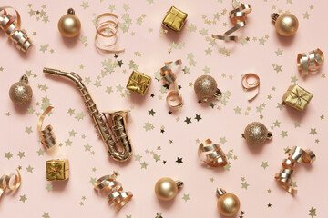 Miniature Golden Saxophone copy with Festive Christmas New Year golden colored decorations on the Peach Fuzz Color of the year 2024 background