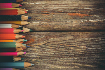 Many colored pencils on a wooden surface, pencils for drawing