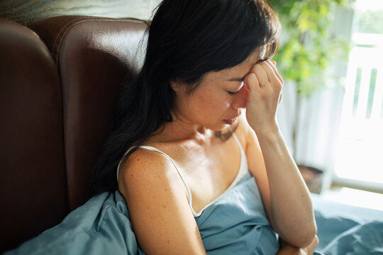 Tired woman holding head after waking up