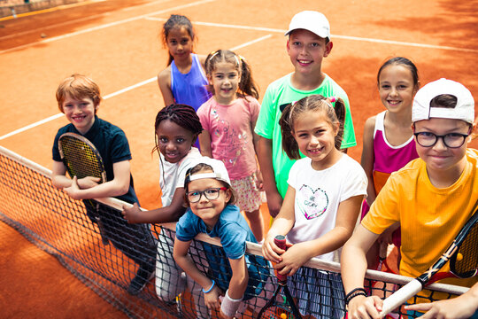 Portrait of diverse children on tennis clay court