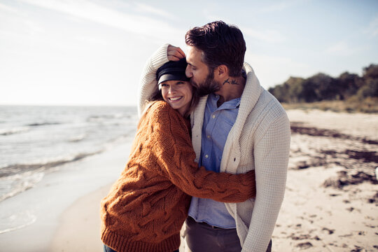 Happy and loving young couple enjoying day at beach in winter