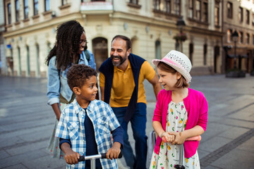 Multiracial couple walking with mixed children in city