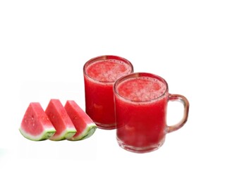 The white background in the picture is red watermelon juice in a clear glass and a fresh red watermelon cut in half next to each other.