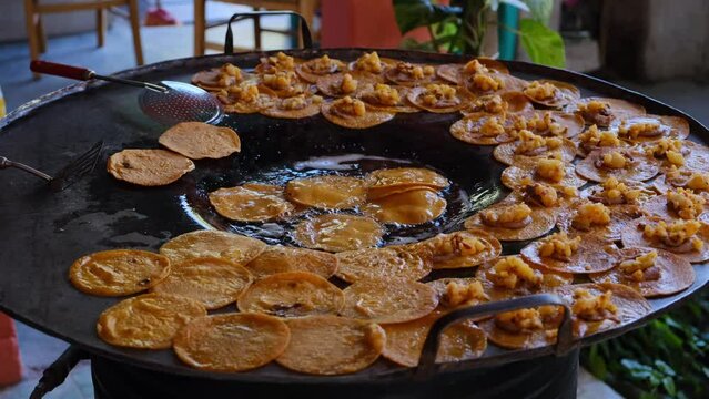 preparation of traditional red enchiladas from Rioverde San Luis Potosi. Fried red tortilla enchilada