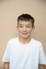 cool 11 years old boy with white t-shirt  in front of brown background in the studio