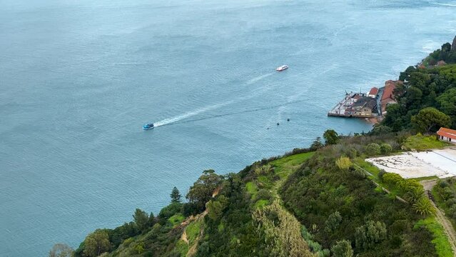 Aerial view of Protugal coast, where forest meets the sea, with boats on the sea