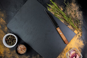 Stone cutting board with herbs and spices on the meat table top view
