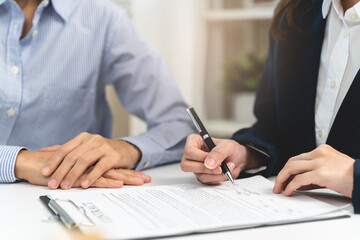Close-up two business people holding pen and signing a contract trade document on the table. - obrazy, fototapety, plakaty