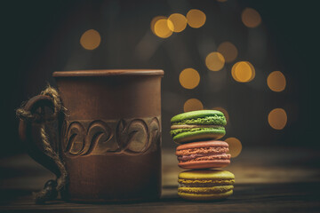 Macarons of different colors and coffee with a beautiful background and blur, treats for loved ones
