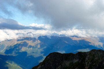 Obraz premium Mountain landscape with white clouds.