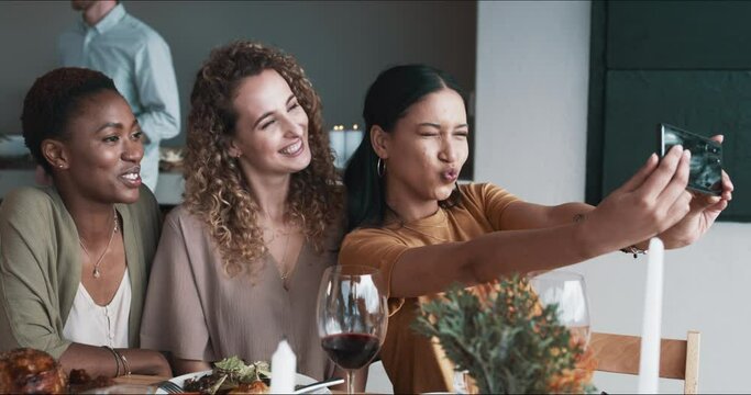 Friends, women and selfie for Christmas party, social media or home celebration at dining room table with red wine and food. Excited group of people with emoji for profile picture and thanksgiving