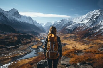 A lone figure stands atop a snow-covered mountain, gazing out at the vast expanse of nature below, their clothing blending seamlessly with the rugged landscape and the clouds above