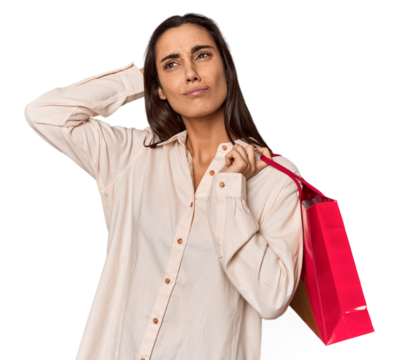 Young woman with Valentine's red bag touching back of head, thinking and making a choice.