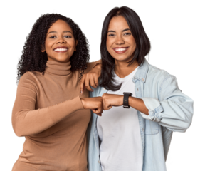 Young Latina friends celebrating with a fist bump